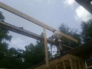 Carpenter setting a ridge beam over a new addition frame — Ice Dam Removal by Roofing Brothers in Riggins