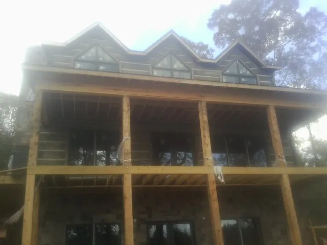 Dormers and porch framing on a large log home under construction — Roof Coating work by our crew in Riggins