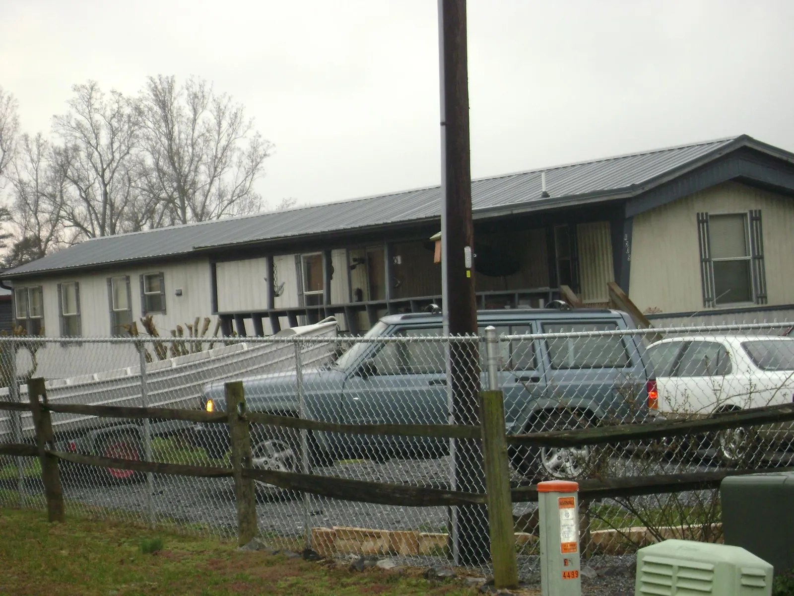 Dark metal roof on a long single story building behind a chain link fence in Riggins