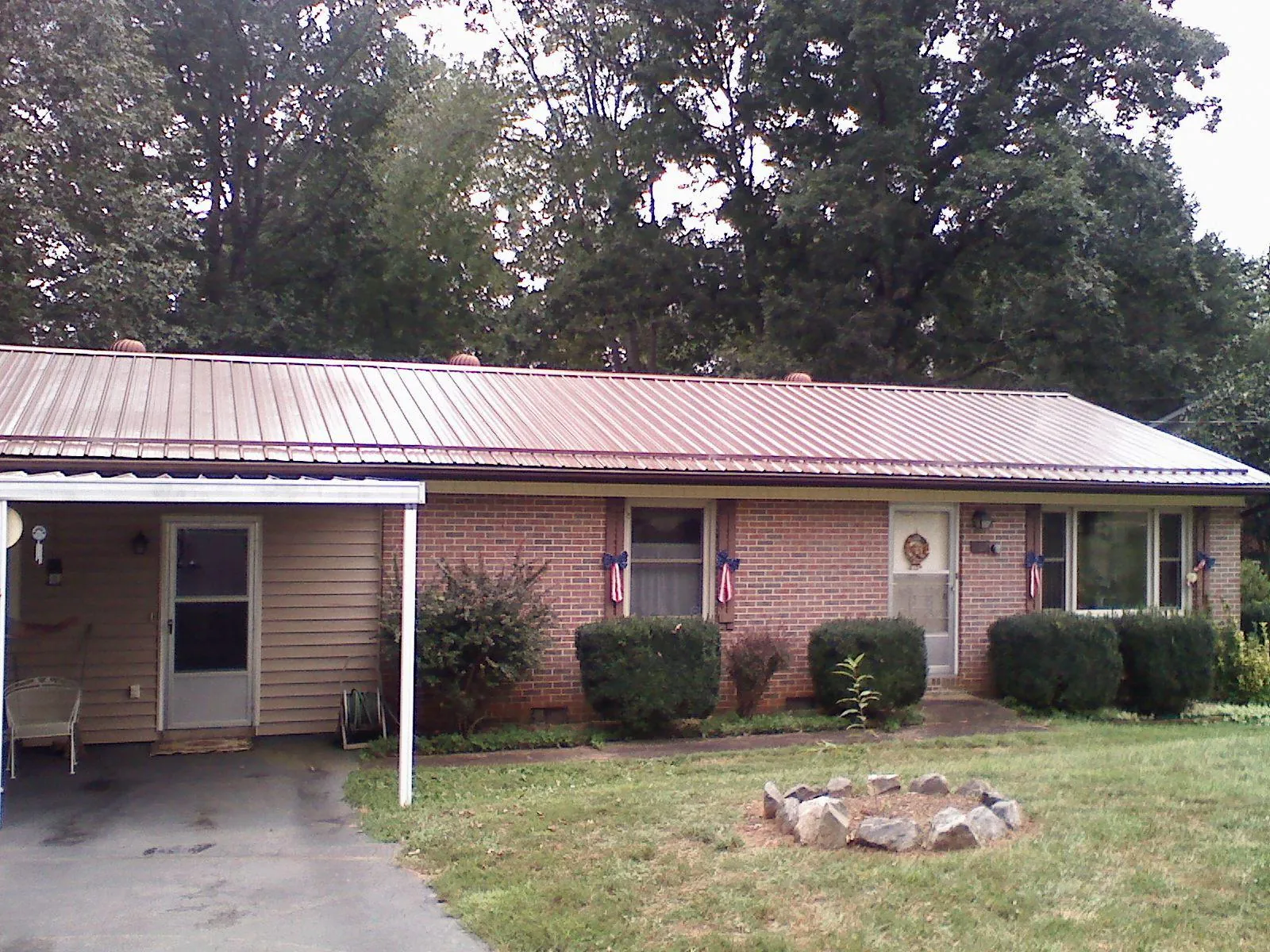 Bronze metal roof and carport on a brick ranch home — Roof Repair work by our crew in Riggins